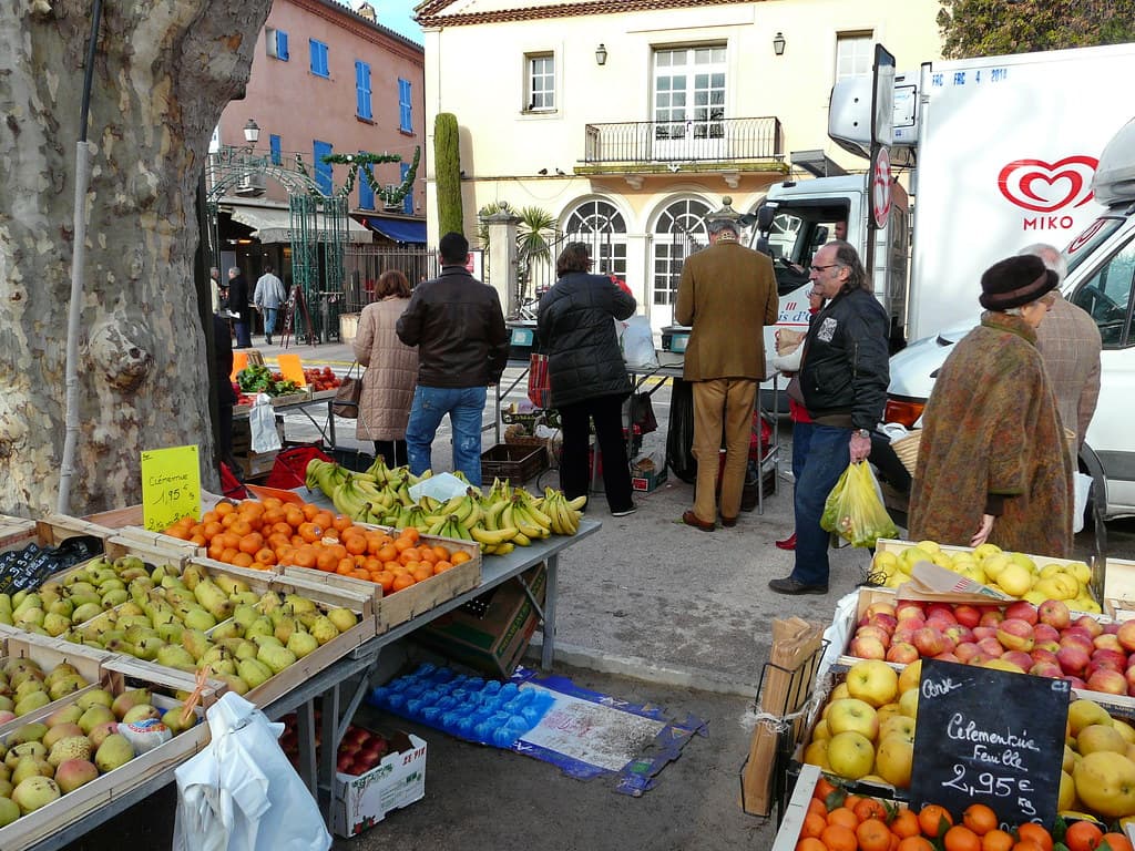 Clients choisissant des fruits et légumes sur un étal en plein air